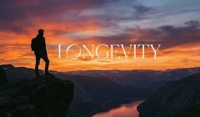 A serene lifestyle image of a person looking out at a golden sunset horizon, featuring the text 'LONGEVITY' to illustrate the anti-aging and mortality-reducing benefits of glucosamine.